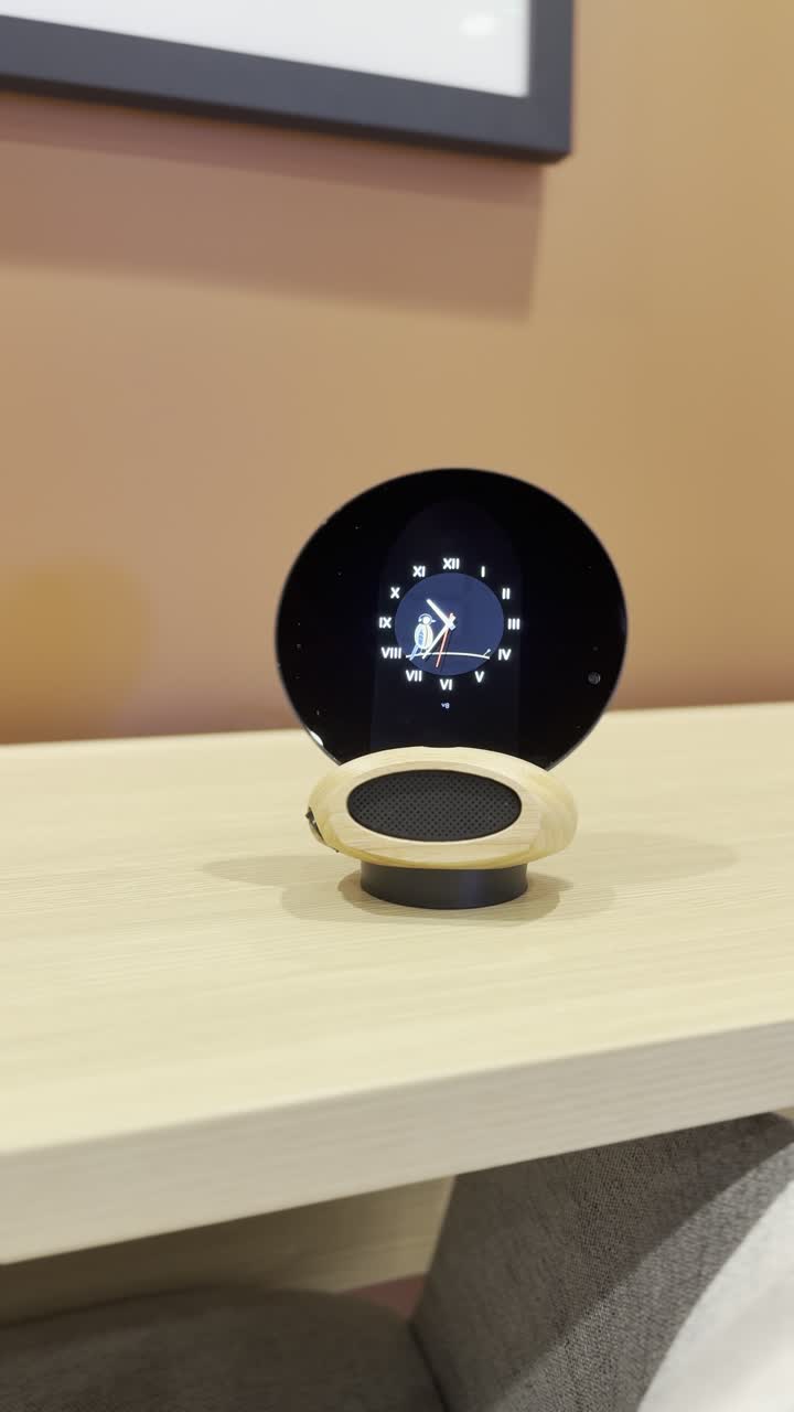 Morph on a light wood desk against a terracotta wall, the clock face lit